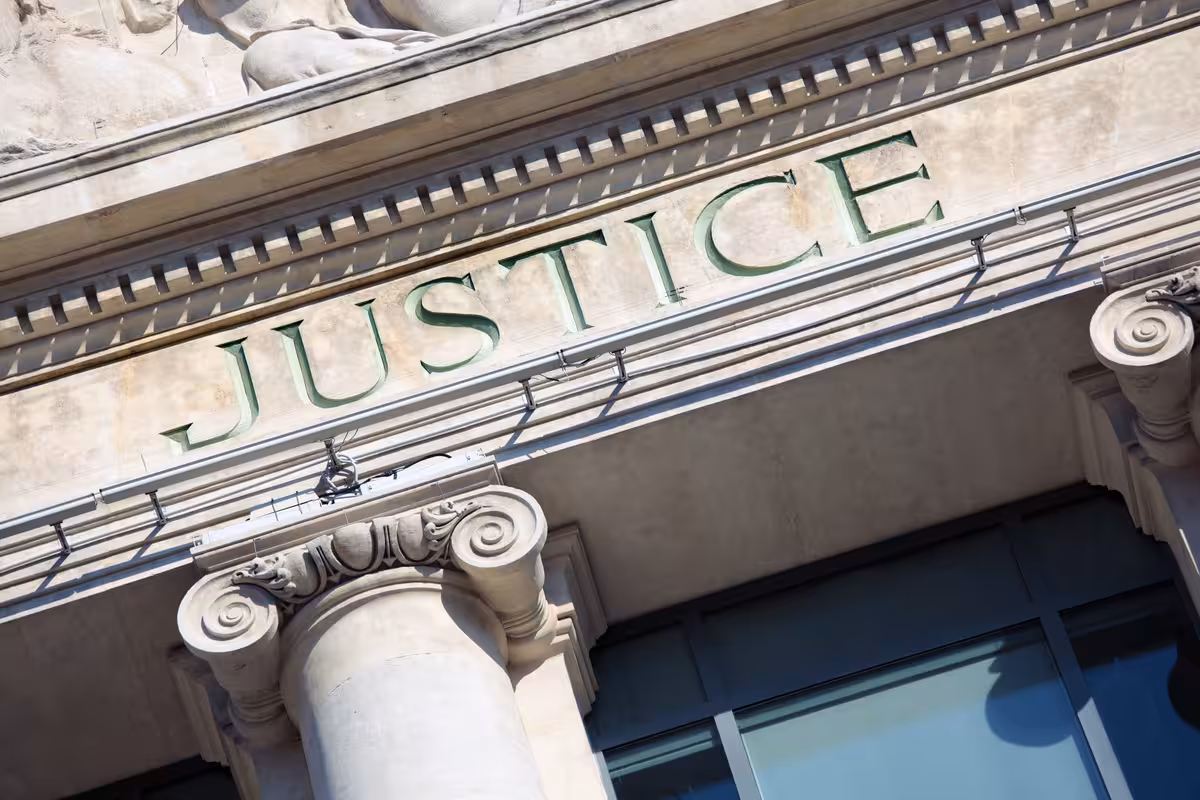 Carved word Justice above stone columns on a courthouse facade
